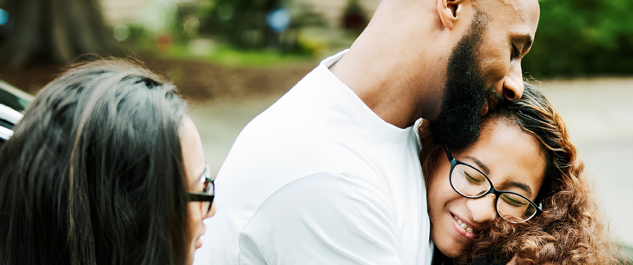 A man embraces a woman wearing glasses, 