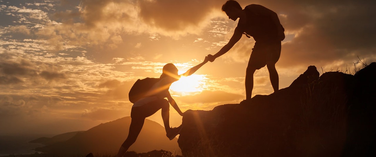 couple climbing up a mountain